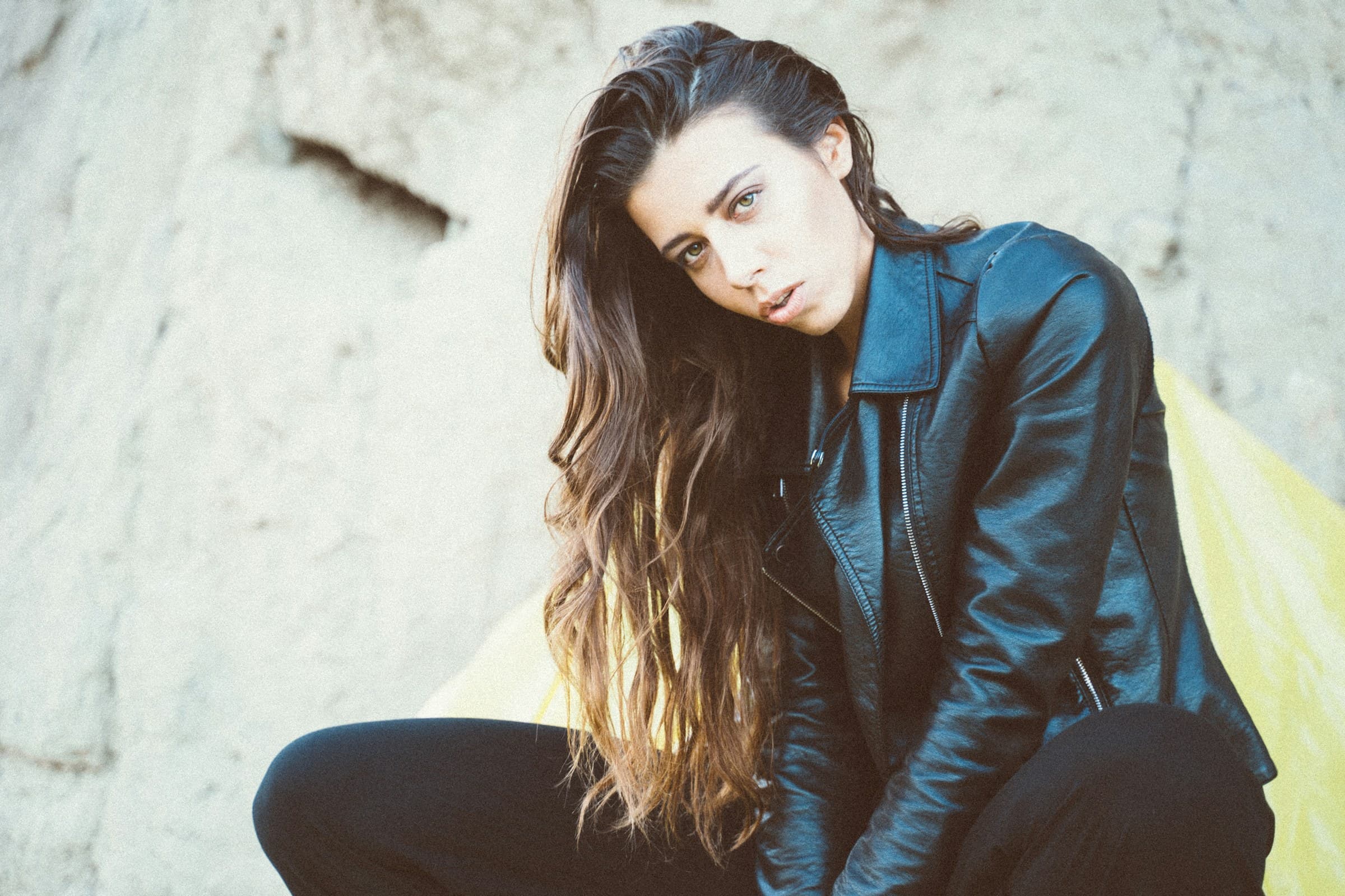 Person wearing a black jacket over a white tee